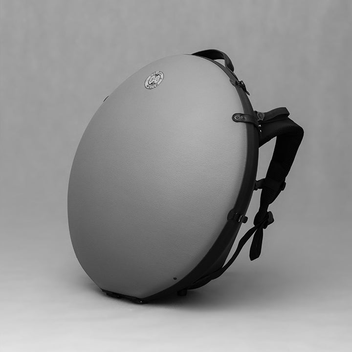 AVAYA Handpan Hardcase bequemer Rucksack gefertigt aus Fieberglaszum Besten Schutz deiner Handpan. Die Handpan Tasche hat einen schönen hellgrauen Kunstlederüberzug und steht auf einem schönen Holzwagen vor einer weißen Wand.