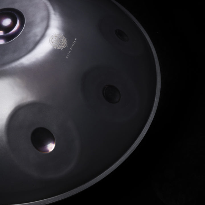 Ausschnitt einer schwarzen Kita Pantam Handpan mit violett poliertem Ding und Dimpel von schräg oben