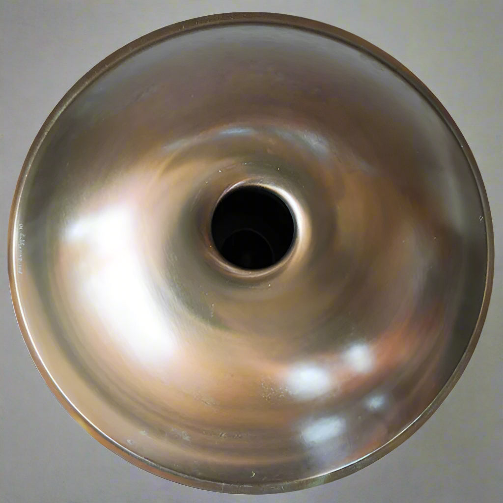 Unterseite einer Svaraa Handpan Drum ohne Bottomnotes mit einem perfekten Spiralmuster. Das Licht spiegelt sich schön in der Oberfläche