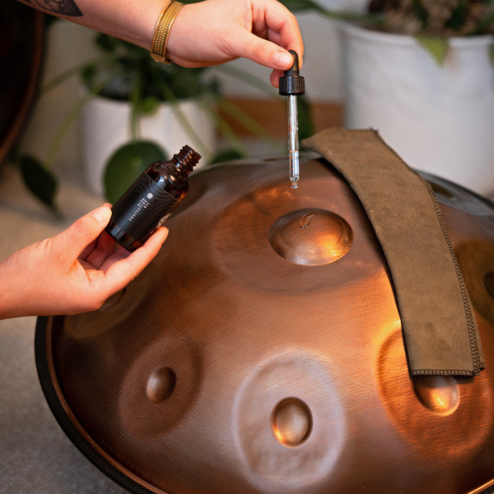 Eine Mini Handpan aus Embersteel wird mit einem Handpan Pflegeöl für Handpans aus nitriertem Stahl und Edelstahl gereinigt.