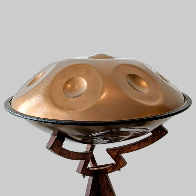 Eine kupferfarbene Edelstahl-Handpan von Spirit Soul auf einem Handpan-Ständer, bereit zum Spielen. Entdecke diese und weitere Handpans bei Handpan.World