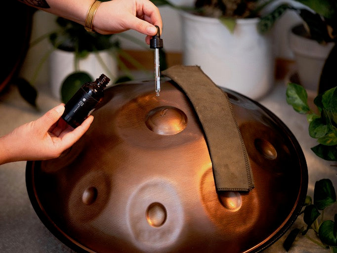 Eine Mini Handpan aus Embersteel wird mit einem Handpan Pflegeöl für Handpans aus nitriertem Stahl und Edelstahl gereinigt. 